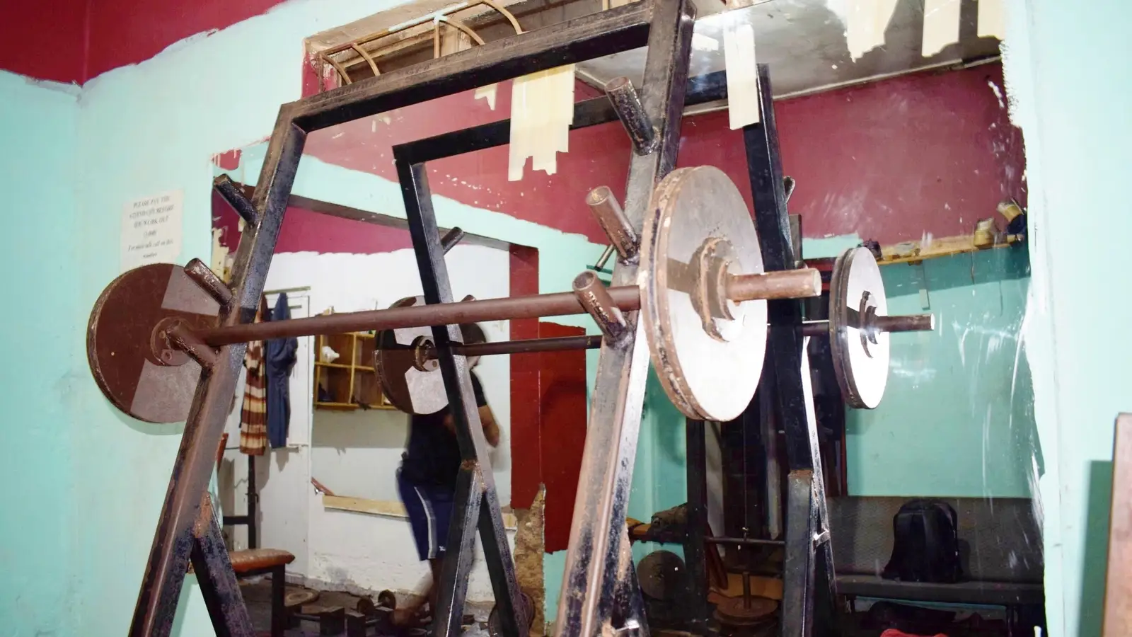 Barbell storage rack in a commercial gym, with specialty bars kept separate from straight bars
