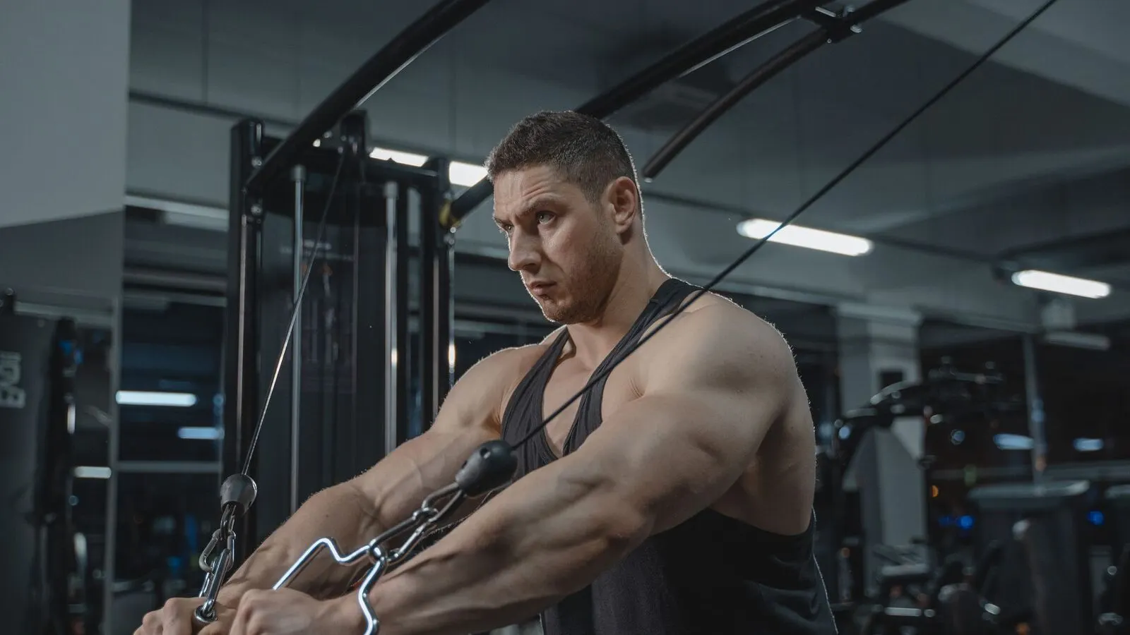 A member training on a cable crossover station in a commercial gym