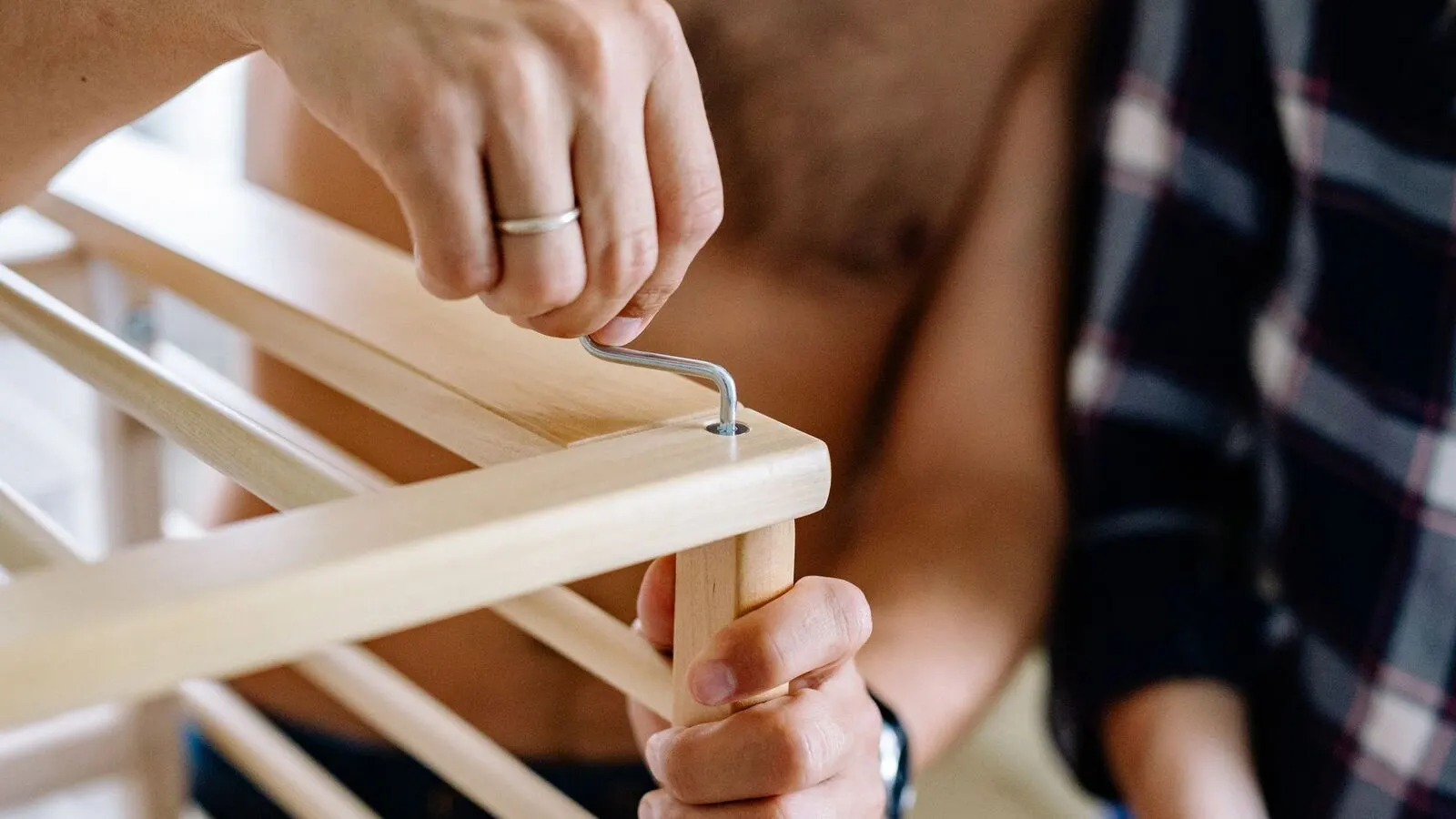 Close-up of a technician driving screws while assembling a frame