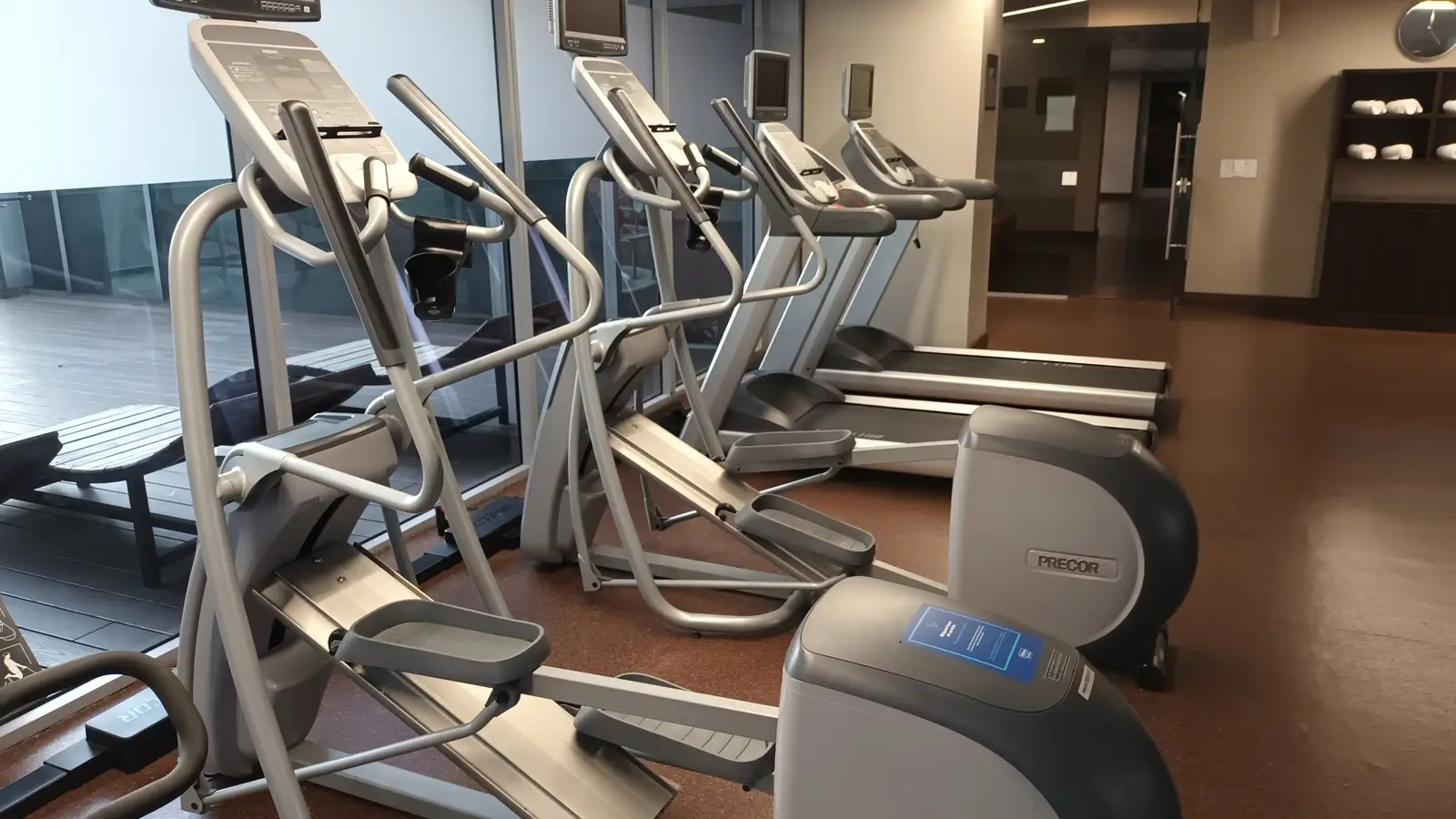 Cardio area in a hotel fitness room with bikes and elliptical trainers